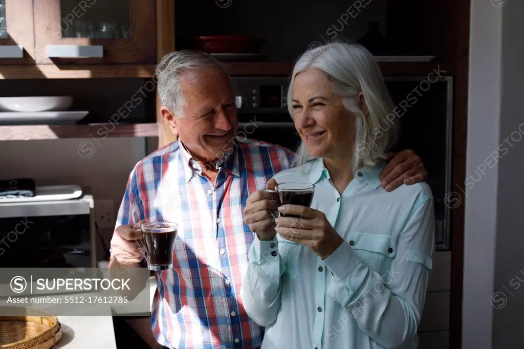 Senior caucasian couple drinking coffee together in the kitchen at home. social distancing quarantine lockdown during coronavirus pandemic