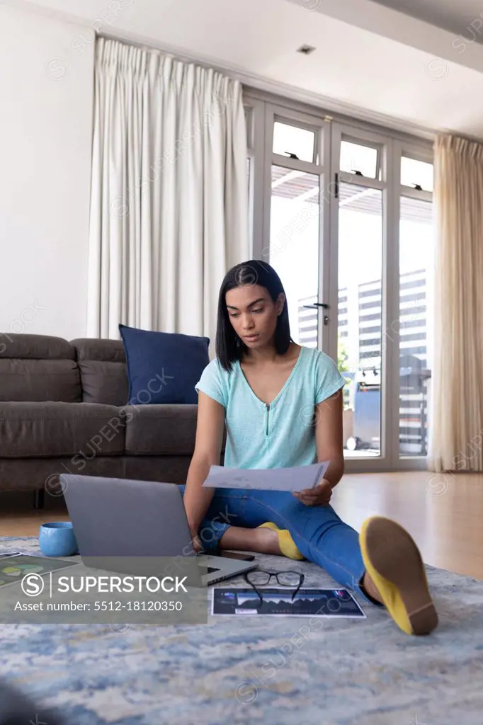 Mixed race transgender woman working at home using laptop talking. staying at home in isolation during quarantine lockdown.