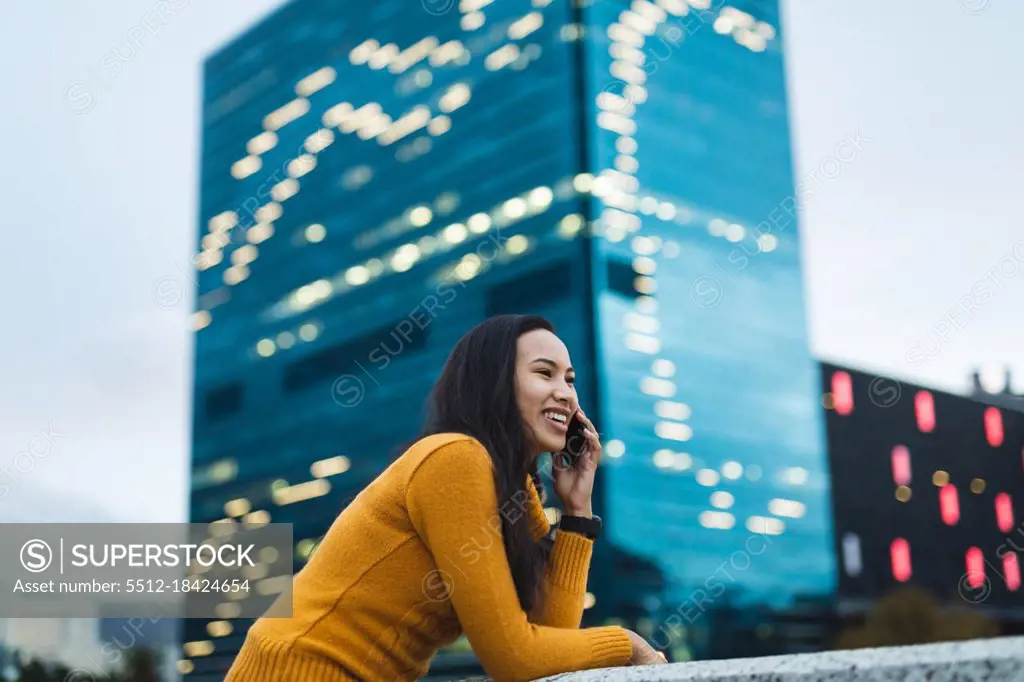 Asian woman using smartphone and smiling in the street. independent young woman out and about in the city.