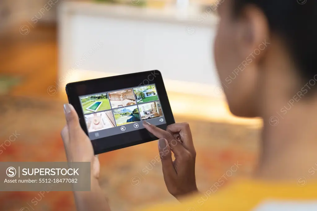 Mixed race woman in kitchen using tablet computer. domestic lifestyle, enjoying leisure time at home.