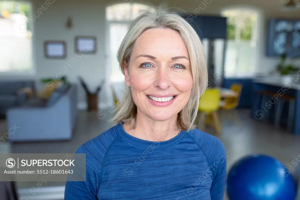 Portrait of happy senior caucasian woman in exercise clothes looking at camera and smiling. healthy, active retirement lifestyle at home.