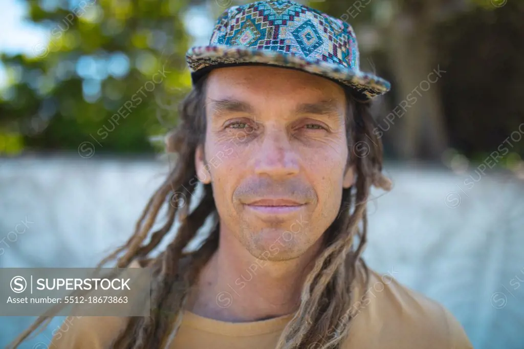 Close-up portrait of male hipster mural painter with long dreadlocks hairstyle wearing cap. hipster people.