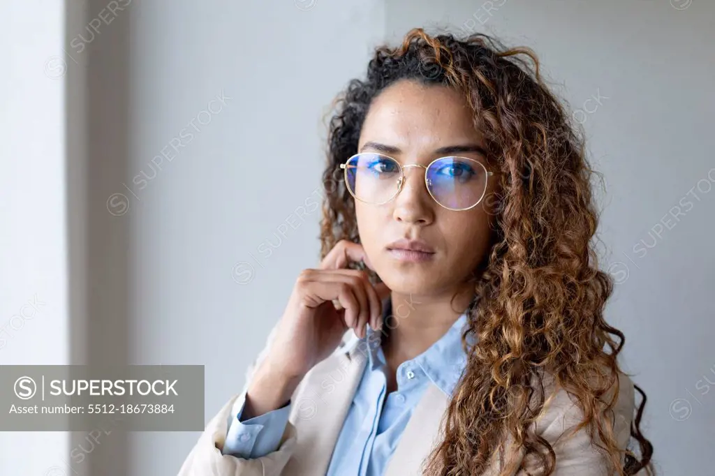 Portrait of confident biracial young businesswoman in eyeglasses at creative office. business and office workplace.