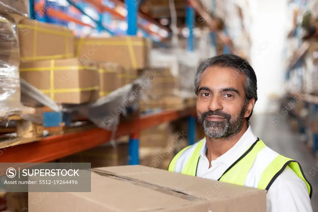 Close-up of male staff carrying cardboard boxes in warehouse. This is a freight transportation and distribution warehouse. Industrial and industrial workers concept