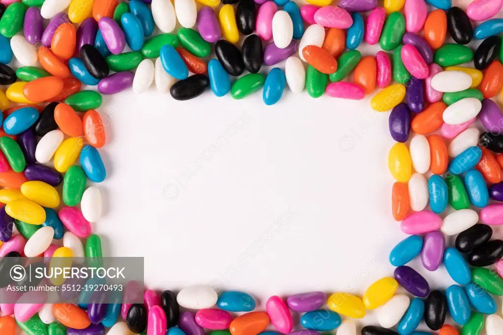 Overhead view of copy space amidst multi colored candies over white background. unaltered, sweet food and unhealthy eating concept.