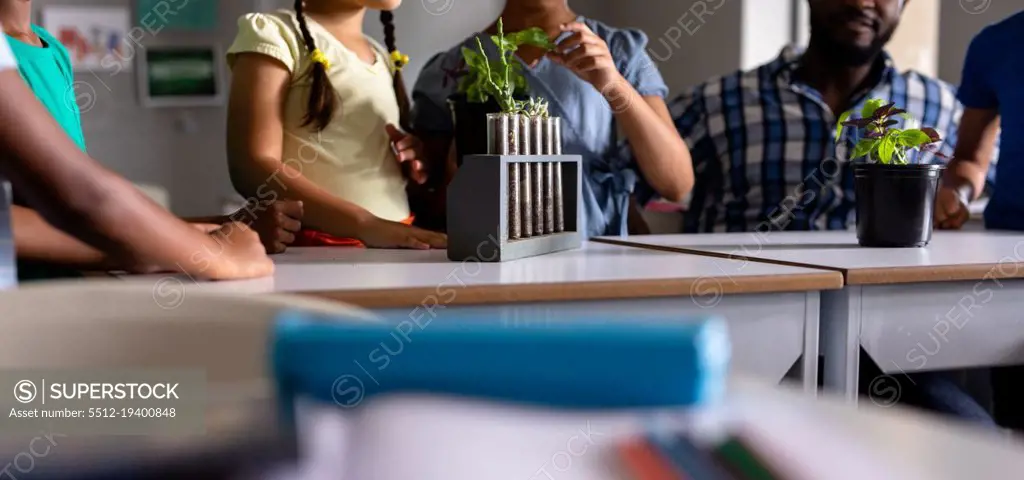African american young male teacher and multiracial elementary students discussing on plants. unaltered, education, childhood, teaching, science, stem and school concept.