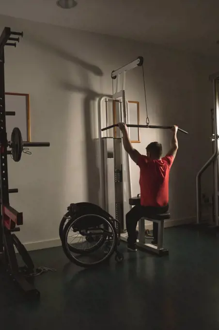 Handicapped man working out lat pulldown training at gym