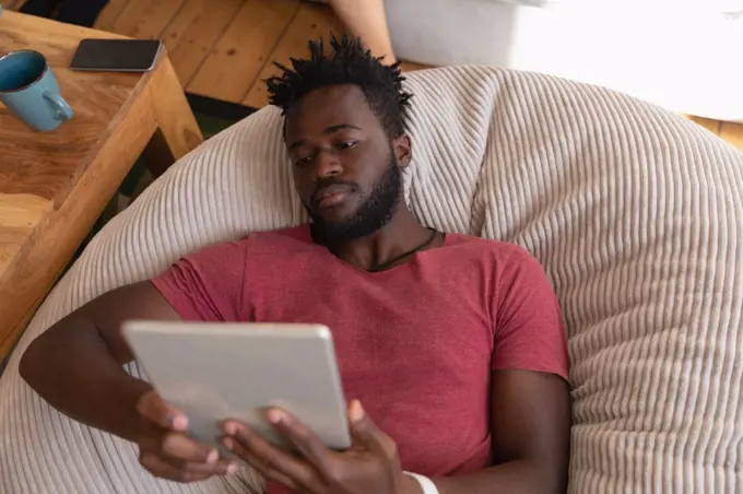 high angle view of African american man using digital tablet in living room at home 