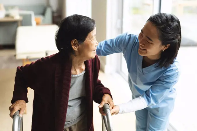 Asian female physiotherapist treating senior female patient at her home. healthcare and medical physiotherapy treatment.