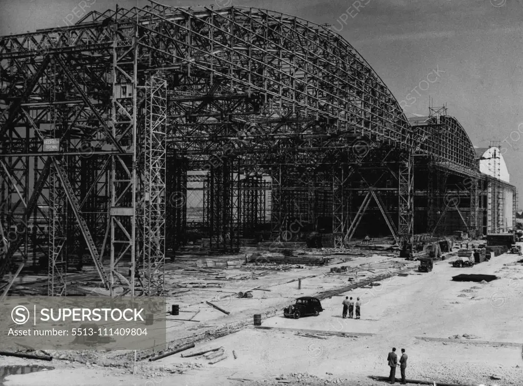 Home For The Brabazon -- The immense size of the partially-completed Brabazon hanger at Bristol dwarfs the car and workers pictured beside it. A ***** steel skeleton which will ***** from the world's largest aircraft hanger is now taking shape at Bristol Airport. Built at a coast of £1,500,000, the hanger will be the home of the Brabazon I, biggest and most advanced land plane yet developed in this country. The aircraft, which will accommodate 80 people in berths and 180 in seats, is also in an 