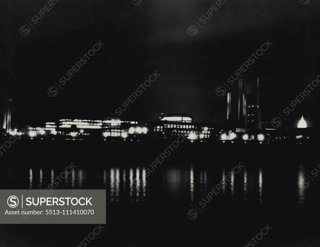 Lights Burn Late In Navy's Busy Gun Factory -- An unusual night picture of the Navy yard at Washington D.C., its lights reflected in the Anacosta River near its junction with the Potomac, where approximately 8,000 men are employed now in day and night shifts making guns for the new cruisers and destroyers financed from public works funds. Repairing of the heavy guns of older ships and the manufacture of other Naval equipment goes on as usual. Not since 191 has the yard been the scene of so much 