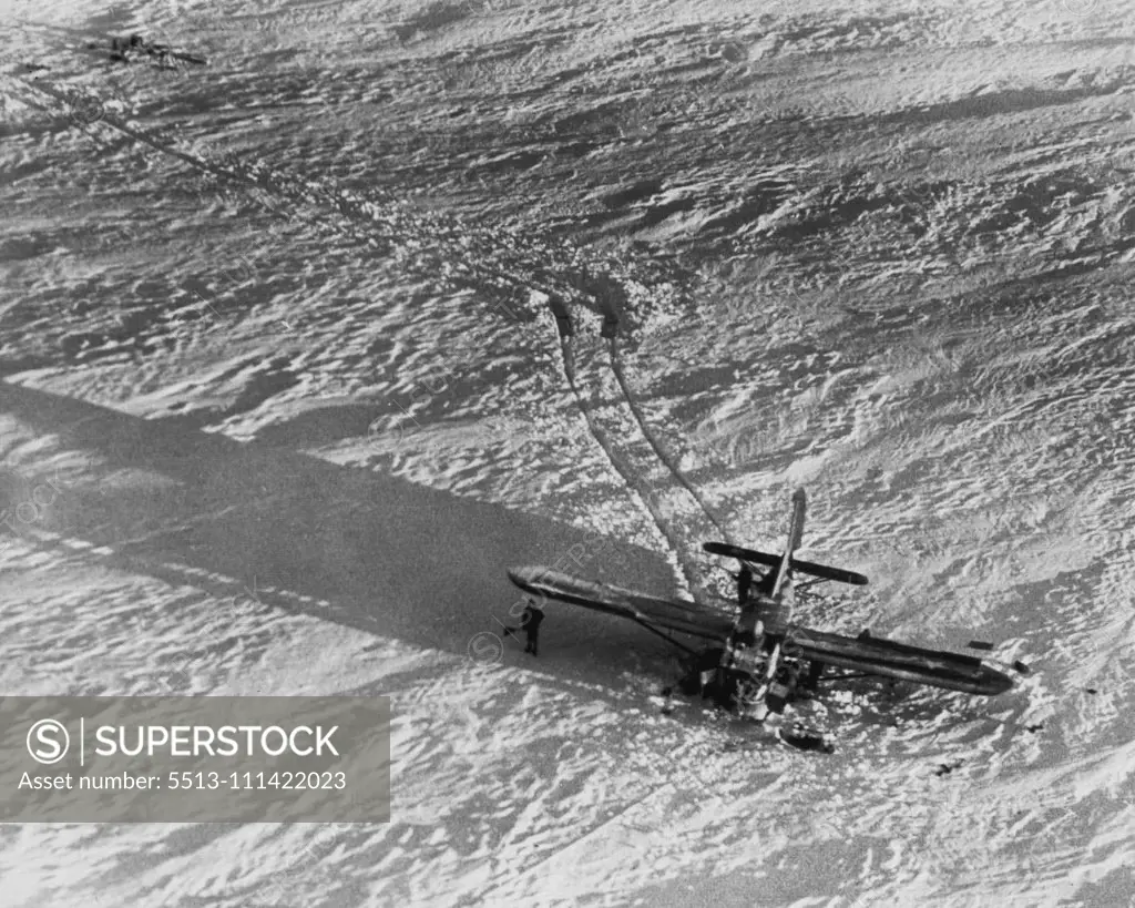 Evidence of A Rescue That Failed -- Several of the 11 Air Force men stranded on the Greenland icecap stand by the glider in which an attempt to rescue them was made by a C-54 making a "snatch" pickup of the glider tow rope. Attempt failed when glider plowed into deep snow causing tow rope to break. Further attempts to rescue men have hindered by stormy weather. December 23, 1948. (Photo by AP Wirephoto).