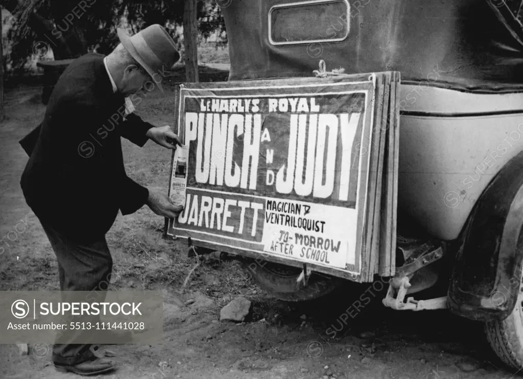 The ***** clips his sign on the back of the car. September 26, 1952.