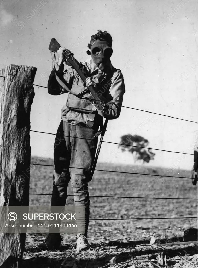 His Bayonet replaced by a wire cutter, this masked soldier of the 4th infantry Brigade forced a way through a fence at Seymour to allow supporting troops to dash to the front line. April 26, 1937.