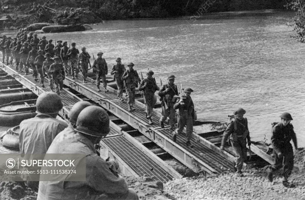 Crossing the River Volturno: Three American engineers watch British troops and transport crossing a Volturno Bridge. On October 13th, 1943, under cover of darkness the Fifth Army made its big assault on the River Volturno, one of the major barriers to advance on Rome - and crossed in force. October 31, 1943. (Photo by Fox Photos).