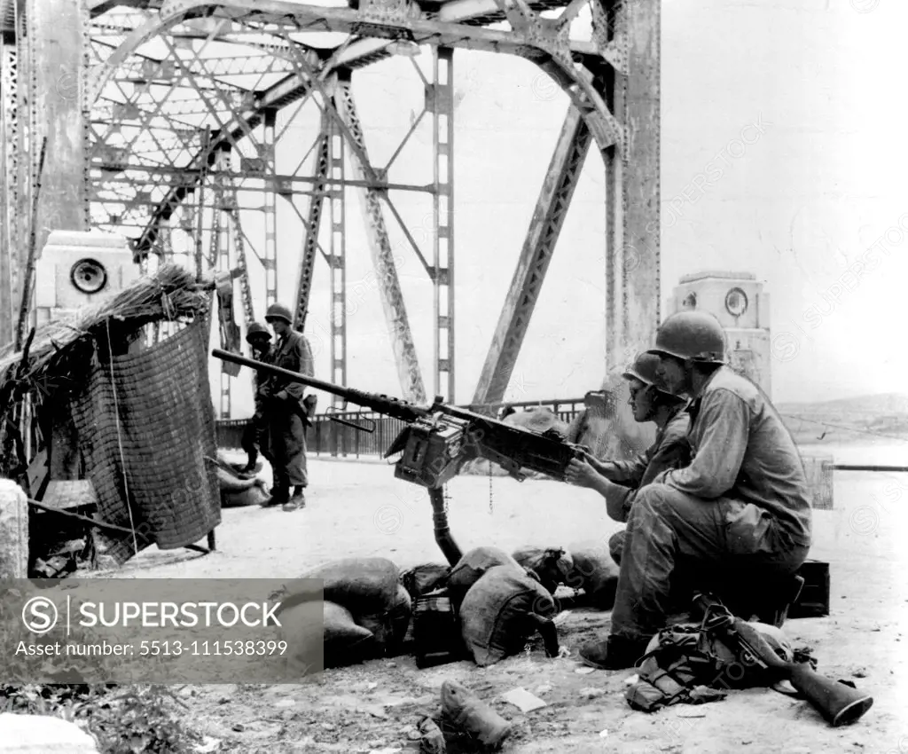 Guard Kum River Bridge - Pvt. Samuel Thomas of Cincinnati and Pfc. Rudolph Cassol (nearest camera) of Pittsburgh, Pa., guard a Kum river bridge with their 50 caliber machine gun. July 1, 1950. (Photo by Charles Gorry, Associated Press).