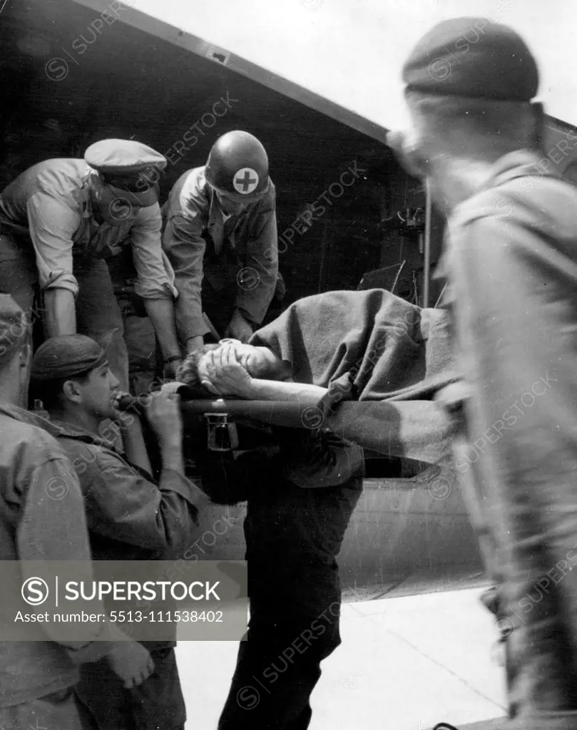 Korean Battle Casualty: Evacuated by air from the battle area in Korea, an American casualty is carried on a stretcher from the ambulance plane at an airport in Japan. July 20, 1950.