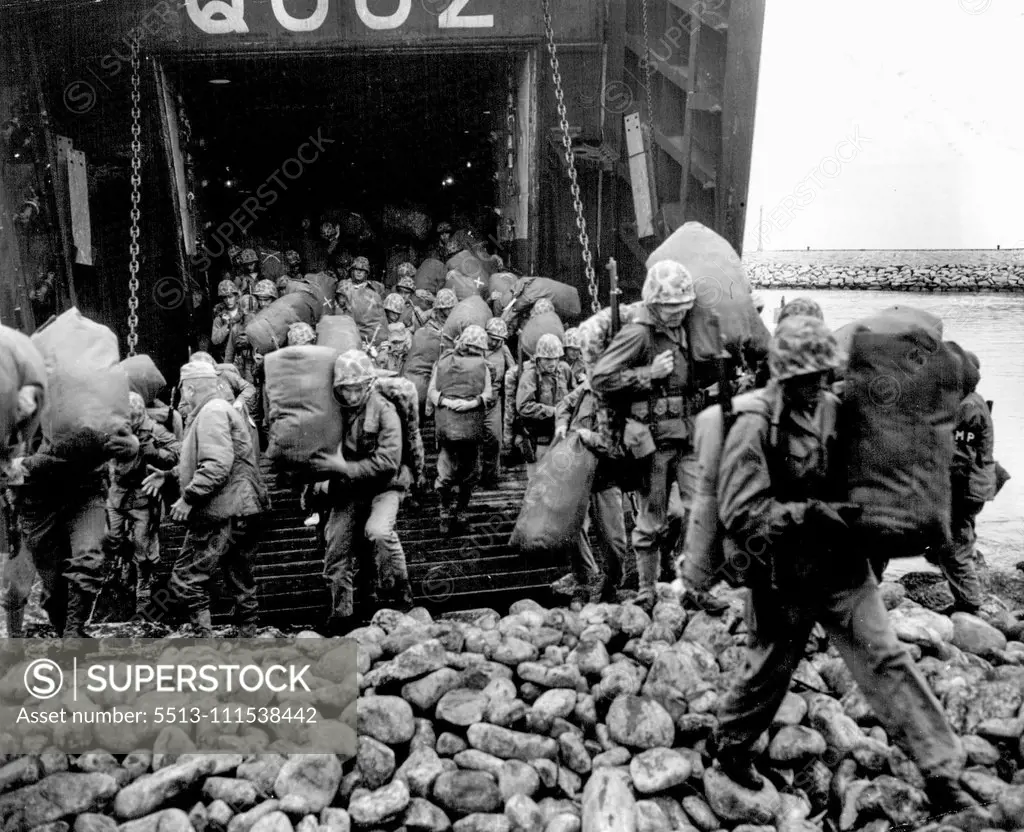 To The Hot War (Fifth - End of Set) - The boys have no illusions about what lies ahead as they set foot on Korean soil for the first time. Carrying their heavy barracks bags down the ramp of the LST, they pick their way over the rough and rocky terrain at their landing point. November 16, 1951. (Photo by ACME).