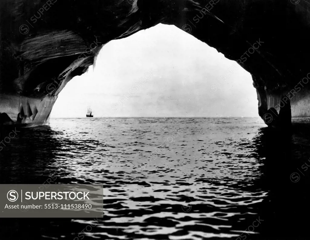 Portal in an iceberg. A remarkable view taken in the interior of a huge cavern worn by the waves in the side of an iceberg. The cavern which penetrated the berg to a depth of 200 yards was 80 feet high at the entrance. May 19, 1931. (Photo by Captain Frank Hurley, Herald Feature Service).