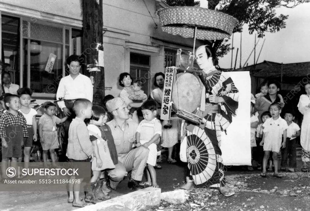 Sightseeing In Tokyo -- Pfc Joseph Miller (Hudson, Ind) 40th U. S. Inf Div, joins Japanese children in watching Tokyo street spectacle , while enjoying pass from his camp in Tokyo, Japan. July 06, 1951. (Photo by Nathan Buchan, U. S. Army Photo).;Sightseeing In Tokyo -- Pfc Joseph Miller (Hudson, Ind) 40th U. S. Inf Div, joins Japanese children in watching Tokyo street spectacle , while enjoying pass from his camp in Tokyo, Japan.