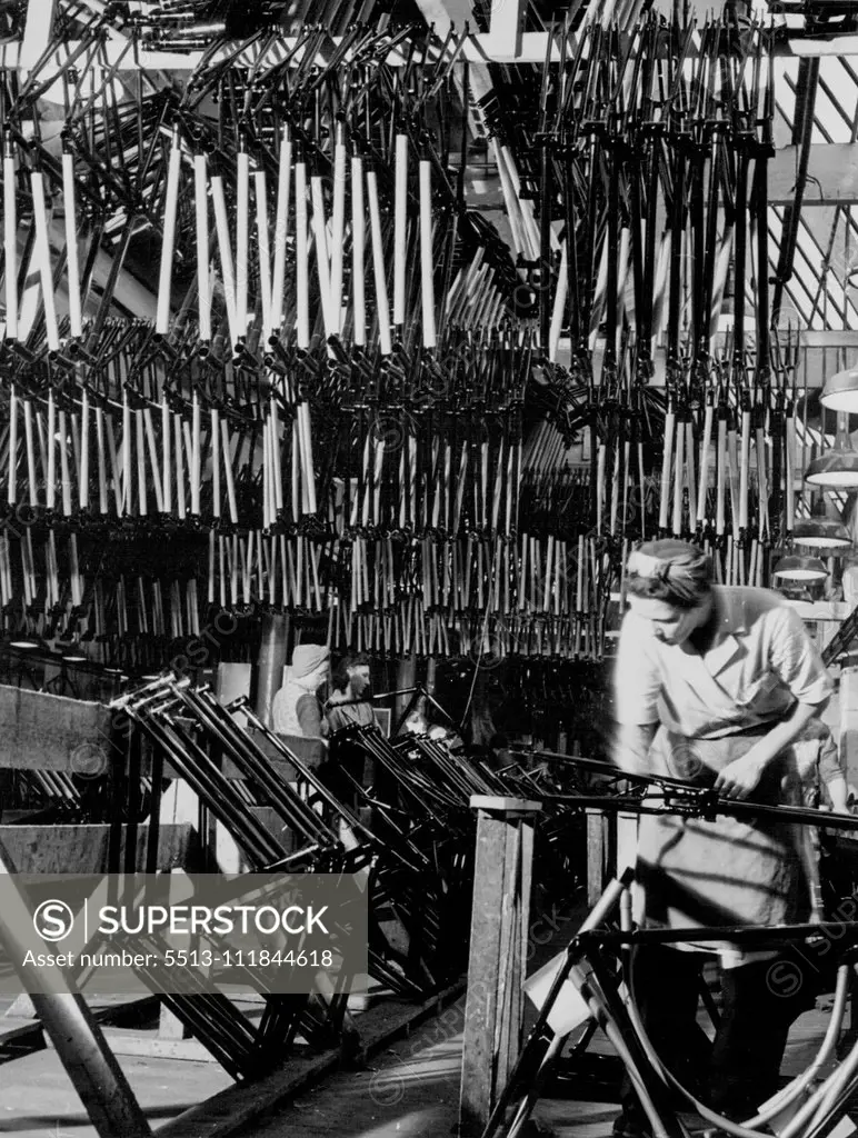 British Bicycles For The World - The frame lining shop. In this ship frames are lined by hand with the manufacturers design and trade mark. Frames are fed into the shop by the conveyor belt system, after being cellulosed and dried. July 09, 1951.;British Bicycles For The World - The frame lining shop. In this ship frames are lined by hand with the manufacturers design and trade mark. Frames are fed into the shop by the conveyor belt system, after being cellulosed and dried.