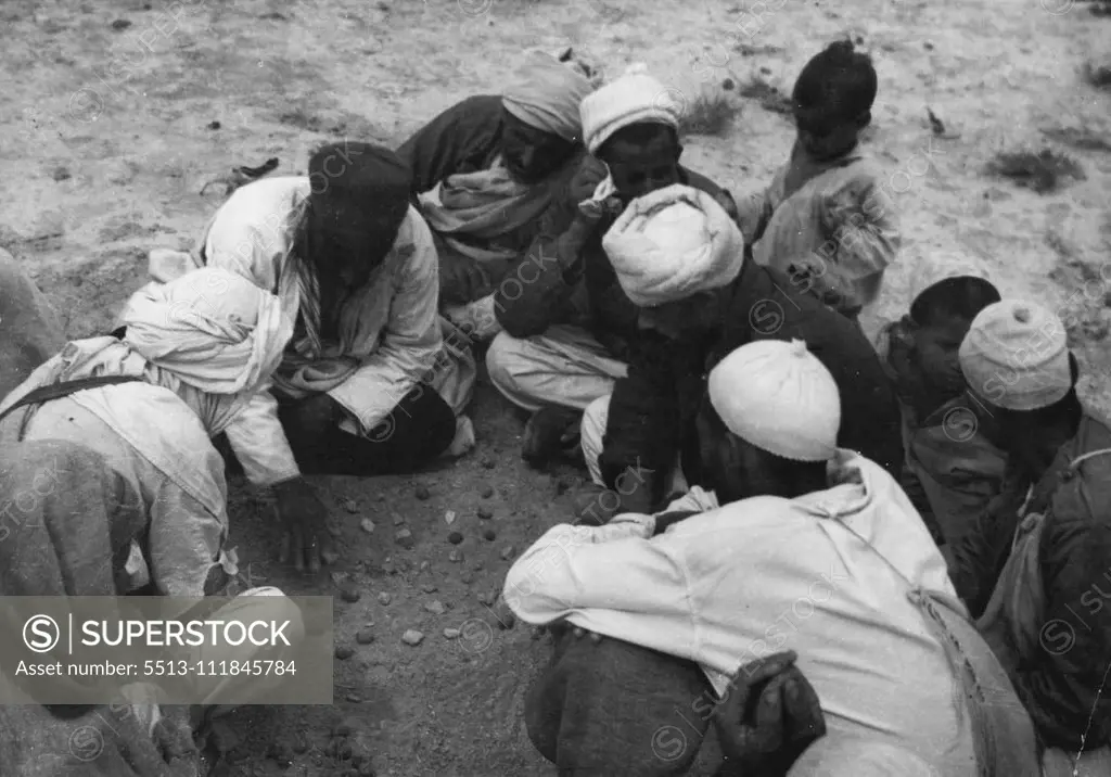 Arabs Of Libya, Unwilling To Return To Italian Domination, Request A Plebiscite -- Men of the Senussi tribe engaged in playing a favourite game - with stones. "The Arab people of Libya wish that tyranny shall not determine their destiny by the handing over of Libya a second time to frightful Italian oppression", said Mansur Kadana, Vice-President of the Committee for the defence of Tripolitania and Cyrenaica, in a statement containing a request for a plebiscite to be made in Libya. These picture