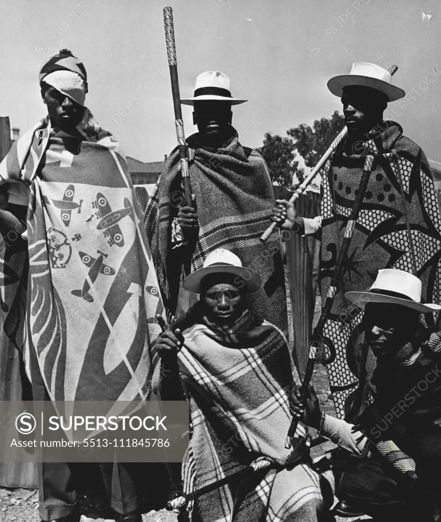 Crime War - A Russian guard at the tunnel that goes under the railwayline dividing them from the Civil Guards. The blanket designs are traditionally Sotho (they are mostly Basutos from Basutoland) and so are the white panama hats and sticks reinforced with colored wire wound round them in gay patterns. October 05, 1952. (Photo by Drum Photo).;Crime War - A Russian guard at the tunnel that goes under the railwayline dividing them from the Civil Guards. The blanket designs are traditionally Sotho