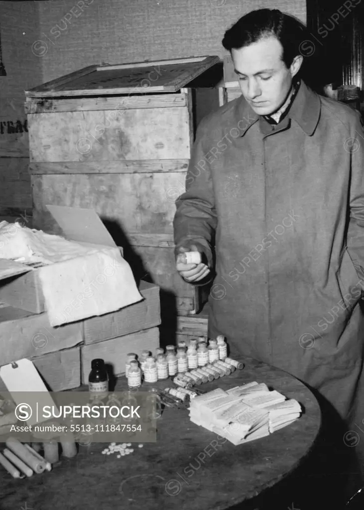 Allied Police Round Up Fake Penicillin -- Peter Domke, charged with being the chief of the fake drug ring stands beside a table littered with chemicals used in the manufacture of fake penicillin. Over a million dollars worth of fake drugs including penicillin have been discovered by Allies police in Berlin American and British CID men arrested seven men and three women on charges manufacturing and selling fake penicillin. It was stated that some of the fake drugs had been administered to a Russi