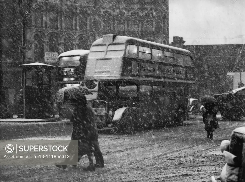 Umbrellas Up - A bus makes its way through the driving snow in Ludgate circus this morning, Jan. 1st, and pedestrians hold their umbrellas at a slant to protect their faces. Picture taken during the small-scale blizzard that hit London. January 19, 1951. (Photo by Associated Press Photo).;Umbrellas Up - A bus makes its way through the driving snow in Ludgate circus this morning, Jan. 1st, and pedestrians hold their umbrellas at a slant to protect their faces. Picture taken during the small-scale