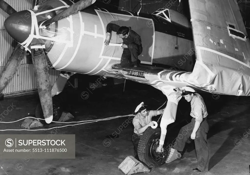 Naval Airman E. Rowe (on wing) and Petty Officers J. Tebby and S. Pearson (RN) taping up all openings in the fuselage prior to it being spayed with a plastic sealing solution. The navy is placing in "mothballs" a number of Firefly and Sea Fury Naval aircraft because of the new planes that are to go into service with the Navy in the near future (Sea Venom Jets and Fairy Gannett aint-sub aircraft). It would be too expensive to maintain these unwanted planes. October 17, 1955. (Photo by Leyden). ;