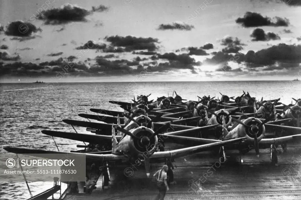 Sunset On The Pacific -- As several flights of fighter planes are tied down on the flight deck, a U.S. Navy aircraft carrier plows through the Pacific, a cloud-studded sunset astern. In the distance, two more U.S. ships sail along the horizon. January 01, 1943. (Photo by Interphoto News Pictures, Inc.).  ;Sunset On The Pacific -- As several flights of fighter planes are tied down on the flight deck, a U.S. Navy aircraft carrier plows through the Pacific, a cloud-studded sunset astern. In the di
