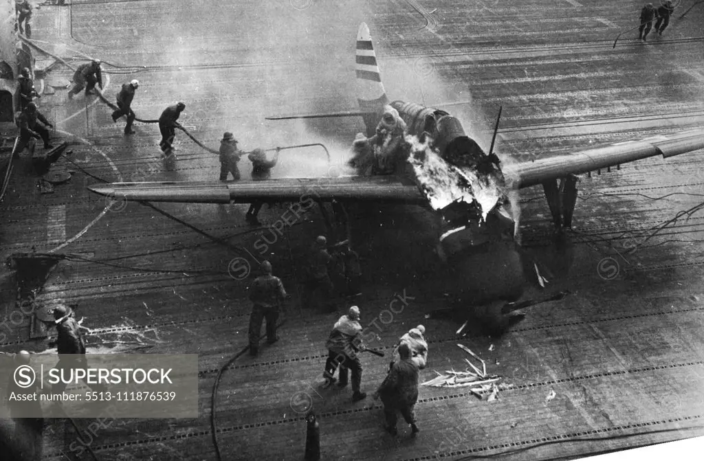 U.S. Sailors Fight Flames -- Two fire fighters free the pilot from the cockpit of the blazing plane as additional crewmen approach to fight the fire. A crewman on the wing has ***** himself between the flyer and the flames, ***** the pilot with his own body as he lowers him ***** second man. The plane's gunner has already ***** through the protective spray spread in ***** right wing. The blaze resulted when the ***** Helldiver bomber failed to engage the ***** gear when it came aboard the U.S. *