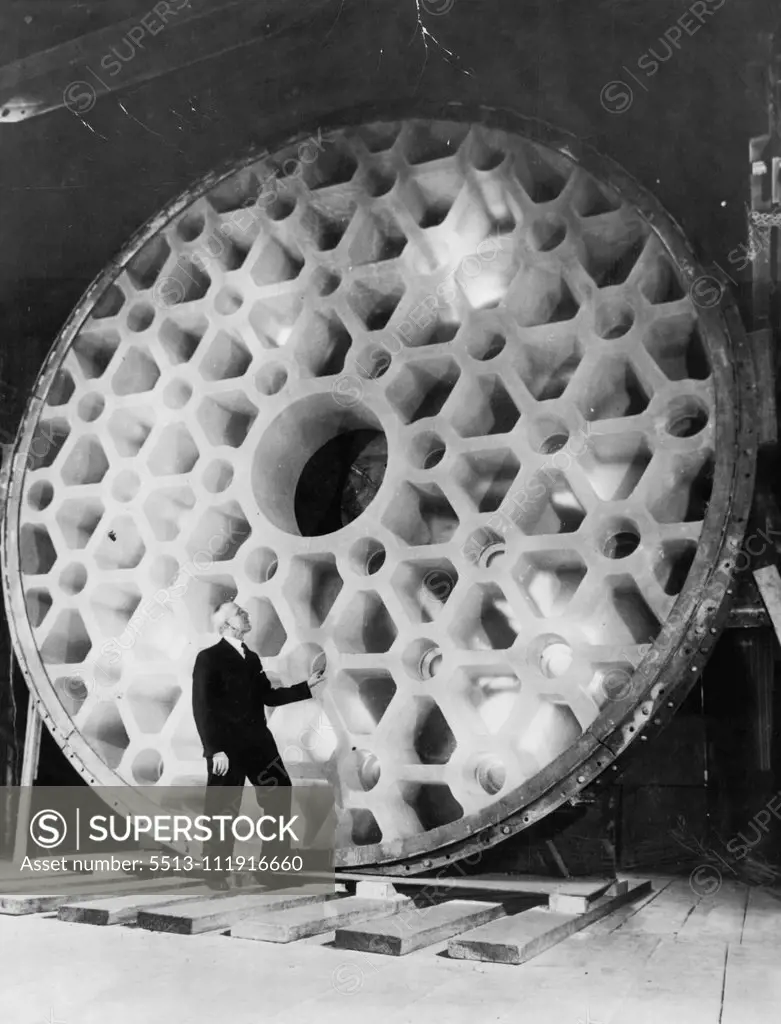 World's Largest Telescope -- John L. Thomas, treasurer of the Corning glass works, contemplates the world's largest piece of glass, the 200-inch telescope disc now being prepared for shipment from corning to California. February 22, 1936. (Photo by Associated Press Photo).