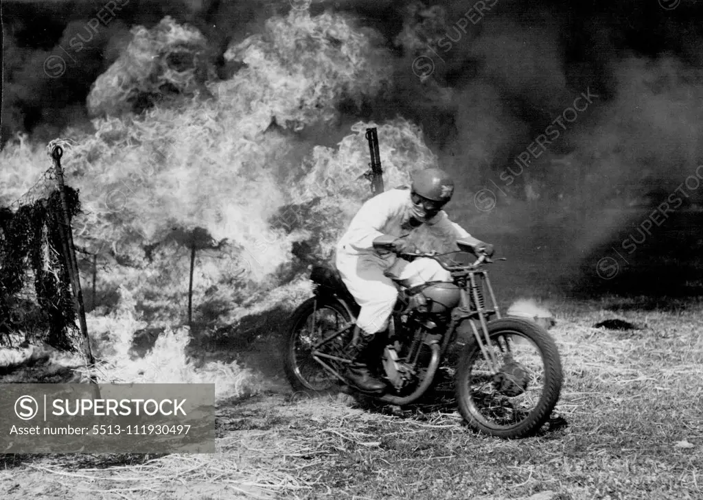 "Mad Johnny" rides Through Fire and Plate Glass" - "Mad Johnny" riding out of his tunnel of fire. The man who wanted to start the festival of Britain with a motorbike plunge into the Thames is busy adding to his 158 cuts and Burns riding his bike through tunnels of flaming straw soaked in petrol, and smashing straight through plate glass wearing nothing worth mentioning except a crash helmet. "Mad Johnny" Davies, 38, Ex. R. A. F., led his "motorcycle maniacs" rodeo team at Princess Risborough (