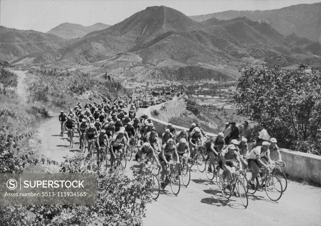 A typical scene in the Tour de France in one of the more restful periods with the field making its way slowly in rugged country. The Tour De France Cycling - the pack in the first slopes of the Pyrenees. August 24, 1953. sports, sport, athlete, athletic, 