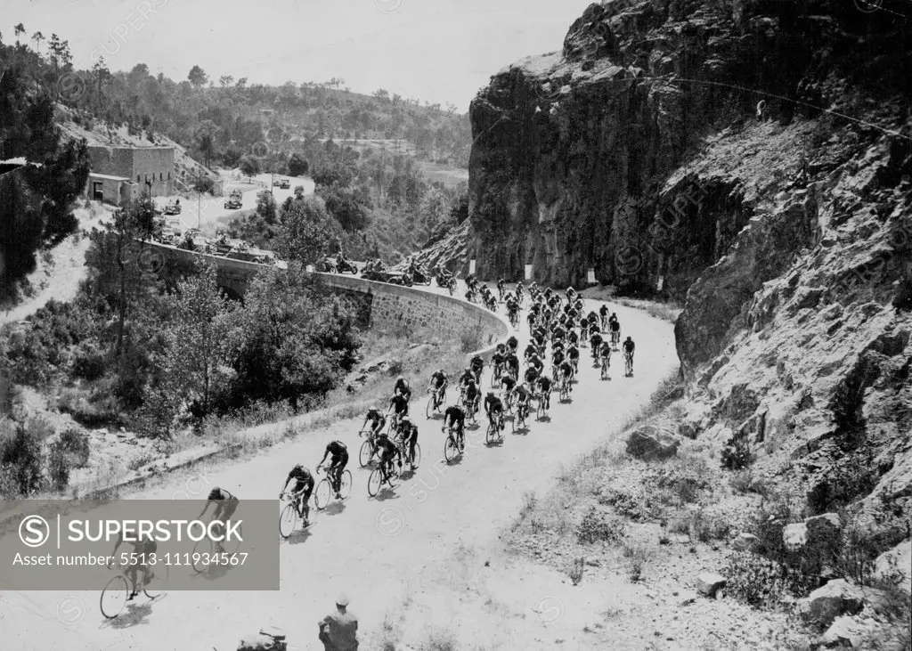 One of the many mountain climbs which make "Le Tour" a back-breaking assignment for competitors. Having a French mountain village Tour de France competitors string out over a winding road on yet another stage of the 25-day ***** 3000 miles race. October 24, 1950. (Photo by Sports And General Press Agency Limited). sports, sport, athlete, athletic, 