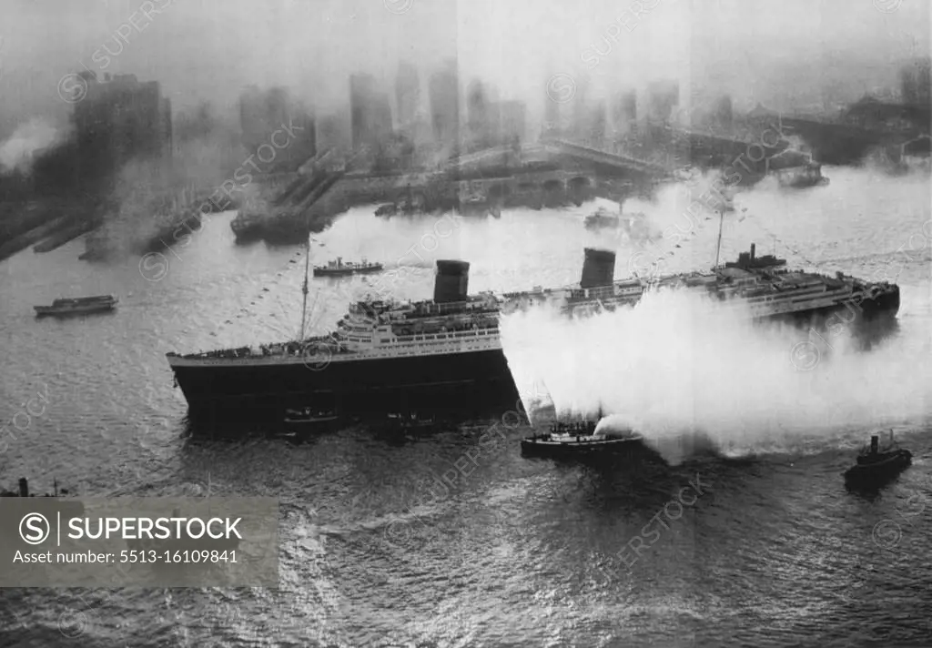 The Queen Completes Maiden Voyage As Luxury Liner -- Accompanied by water stream throwing fireboats, tugs and other craft as well as airplanes over head, the British luxury liner Queen Elizabeth, largest ship afloat, makes her way up New York harbour in the early morning haze today completing her first transatlantic voyage in passenger service. The Queen made many ocean voyages carrying troops during the war but this was her maiden trip since being refitted as the luxury liner she was originally intended to be. October 21, 1946. (Photo by AP Wirephoto).