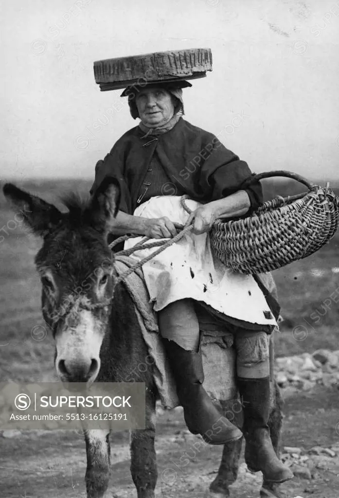 The "Cookle Women Of Penclawdd" -- A typical cockle women is Mrs. Annie Rynon, and as the tide goes out so does Mrs. Eynon on her donkey, complete with the sieve which is the chief implement of her trade. The block Atlantic winds which sweep the desolate sands of Llanrhidian do not daunt her nor the possibilities of "unexploded shells and bombs about which large notices warn her. Women wearing sieves on their heads and riding tiny donkeys and pony-carts make their living by searching for cockles left by the ebbing tide, Llanrhidian Sands, South Wales is Britain's biggest cockle centre, and the families who work the cockle beds have done so for generations. One of the cockle women of Penclawdd, Mrs. Annie Eynon. She collec's cockles on the Llaurhidrau Sands. October 23, 1947.