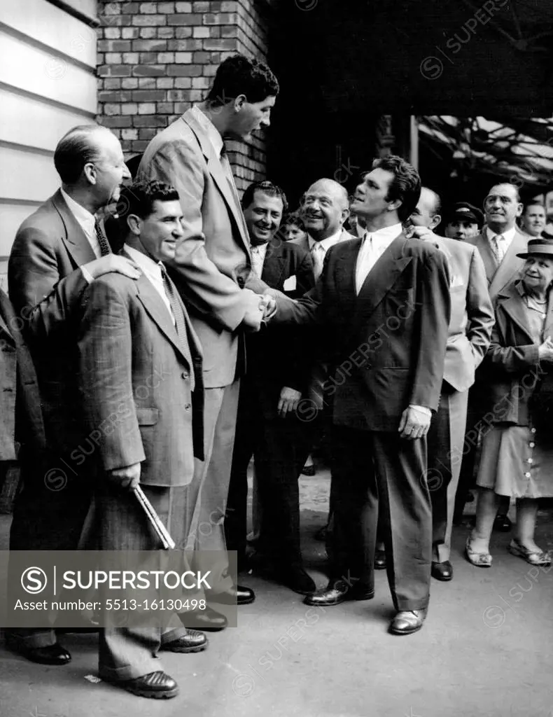 South African Heavyweight - Plus South African heavyweight-plus, Ewart Potgieter, 7 feet 2 inches, dwarfs former world champion Freddie Mills, himself no stripling, and Joan Walker, on his arrival at Victoria Station, London, from Paris today (Tuesday). Ewart, who weighs 22 stone 7 pounds, is in London to prepare for his first fight in England a white city on September 13. Ewart 8½ inches taller than Primo Carnera, was discovered then working on a farm a hundred miles from Johannesburg. He has a 92 inch reach, 26 inches longer then world heavyweight champion Rocky Caroline. August 02, 1955. (Photo by Reuterphoto).