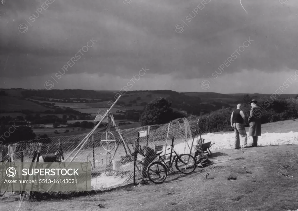 Back to the Stone Age -- The entrance guarded by wire netting. Members of the Worthing Archaeological Society were to-day exploring the interior of a Neolithic flint mine at Cissbury Hill on the Sussex Downs, to find relics of Stone Age Britons. September 20, 1953. (Photo by Daily Mail Contract).
