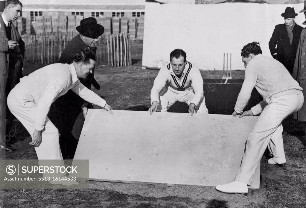 A New Concrete Cricket Pitch -- Left to Right: Len Muncer, of Glamorgan; Bill Edrich, England and Mieddlesex; and Eddie Ward, of the Chiswick school demonstration the easy laying of the concrete sections of the pre-cast cricket pitch. March 04, 1949. (Photo by Sport and General Press Agency Limited).