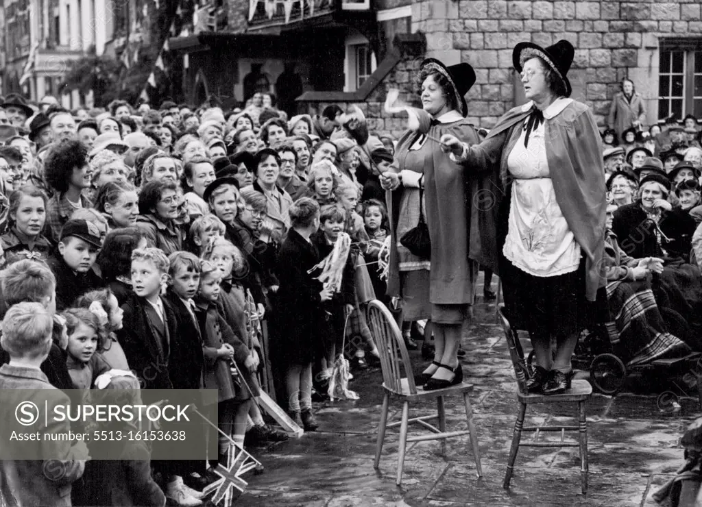 Climax of The Queen's Visit to Wales. Welsh women in national dress lead the chorus singing welcome to the Queen as she arrives at Caernarvon. Yesterday saw the climax of the the Queen's Coronation visit to Wales. The principal item in the day's ceremonies was the Queen's visit to Caernarvon Castle. In a pavilion erected in the stately court flanked by the great walls of this medieval Bastion, her majesty received many North Wales Dignitaries. July 11, 1953. (Photo by Paul Popper).