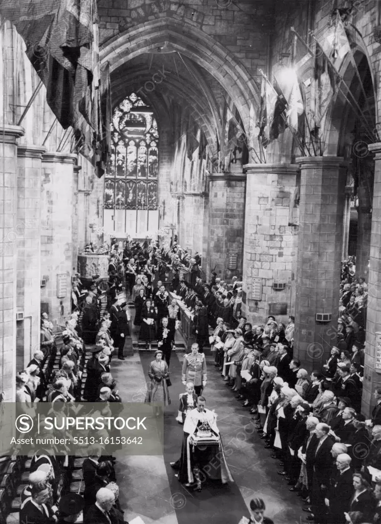 The Queen in St. Giles Cathedral. The ancient Crown of Scotland is carried on a cushion preceding the Queen and the Duke of Edinburgh in the St. Giles Cathedral here during the National Service of thanksgiving. The Queen and the Duke are currently making a State Visit to Scotland. June 25, 1953. (Photo by Planet News Ltd.).