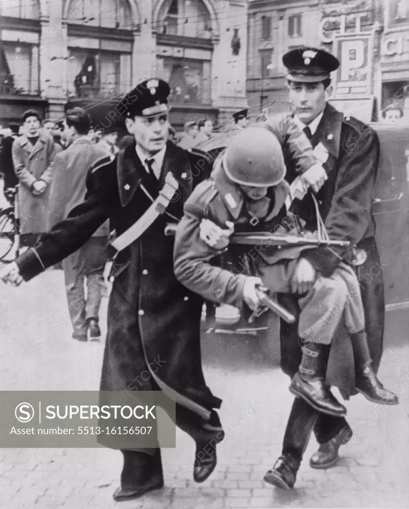 Cop's Life No Cinch In Rome - A roman policeman, one of several injured in a clash with students and other demonstrators demanding the return of Trieste, is carried from the scene by two colleagues of the Carabinieri, Italian national police organization. The injured cop still holds his club and automatic rifle. March 28, 1952. (Photo by AP Wirephoto).
