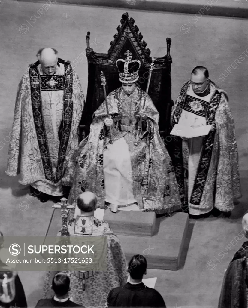 The Queen is Crowned. She site in St. Edward's Chair wearing the St. Edward Crown, and flanked by the Bishop of Bath and Wells (rt) and the Bishop of Durham, and the Archbishop of Canterbury is in the foreground. She wears the Robs Royal, the Stole Royal, and in her right hand is the Sceptre with the Cross, and in her left, the Rod with the Dove of Mercy. June 2, 1953.