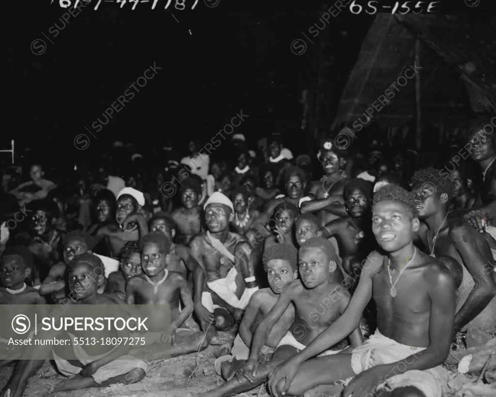 ***** natives watching their first movie show, which was ***** and wonder to them, as may be seen from ***** in their eyes. The animal cartoon appealed to *****. May 08, 1944.