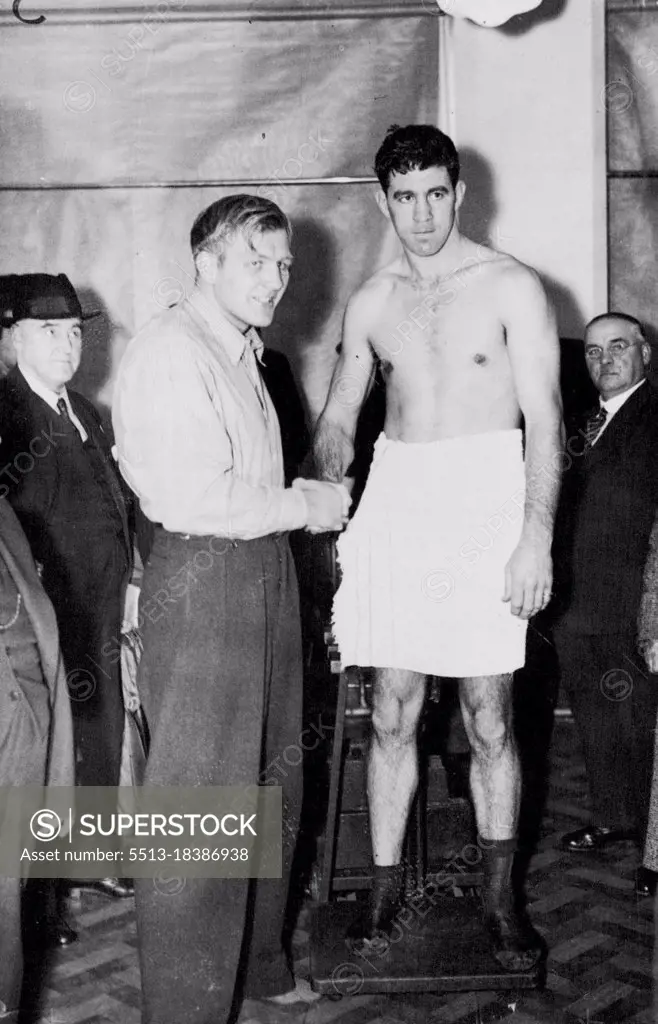 Strickland And Neusel Weigh In For Big Fight -- Walter Neusel (left) and Maurice Strickland on the scales at the weigh-in for the big fight.Walter Neusel, Germany Heavyweight, is fighting Maurice Strickland, New Zealand, at Wembley Stadium here tonight in an attempt to make a come-back after his recent defeat by Tommy Farr. In a visit to the United States a month ago Strickland had considerable success. October 19, 1937. (Photo by Associated Press Photo).