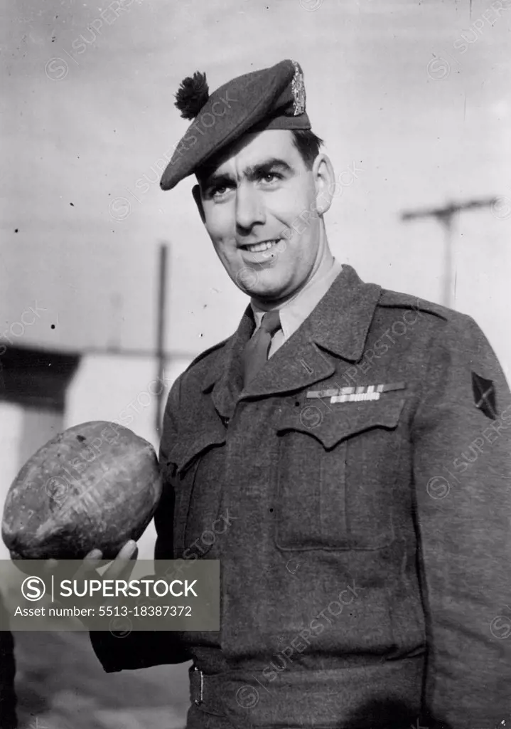 Korea V.C. Home -- Private Bill Speakman with the coconut he brought home from Korea for his kid brother Bert.Private William Speakman, who was awarded the Victoria Cross in Korea, was greeted by the Mayor of his home town Altrincham, Cheshire, when he arrived from the Far East at Lyneham Airport to-day. January 29, 1952. (Photo by Daily Mail Contract Picture).