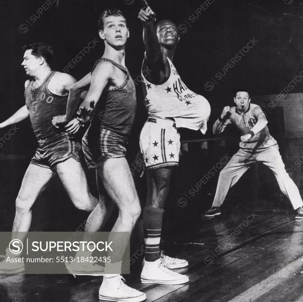 Hidden ball gag by "Goose" Tatum, who pops the ball under his shirt while indicating a pass fools nobody but delights the crowd. December 30, 1953.