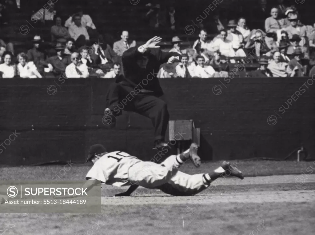 Physically as well as spiritually, umpires risk a beating. In this picture an agile umpire is avoiding being knocked about by a diving base runner. Umpires run the risk of being cut by illegal tips worn by players. May 1, 1952. (Photo by Look Magazine).